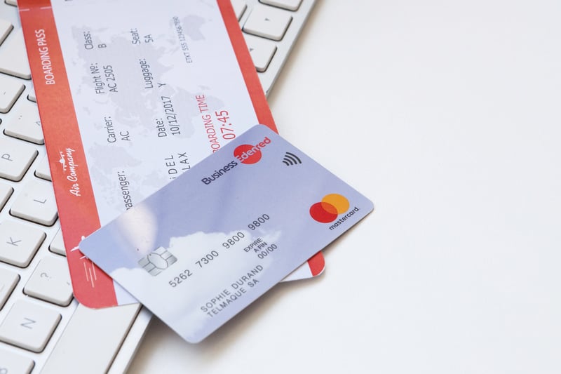 a Edenred Business card shown lying on a table on top of a flight ticket and keyboard