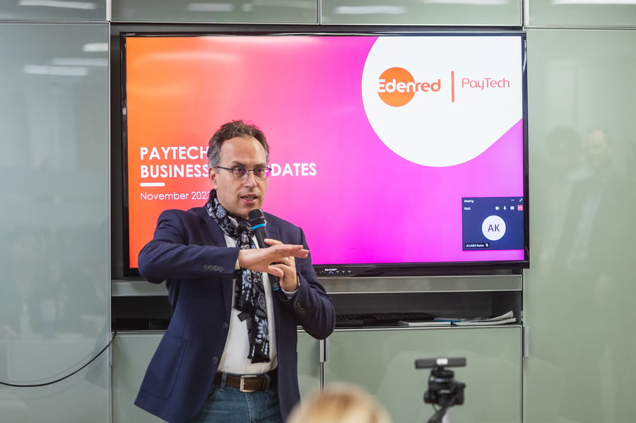 A man, Edenred PayTech director, Andrea, shown presenting in front of a screen projector on a wall in an office