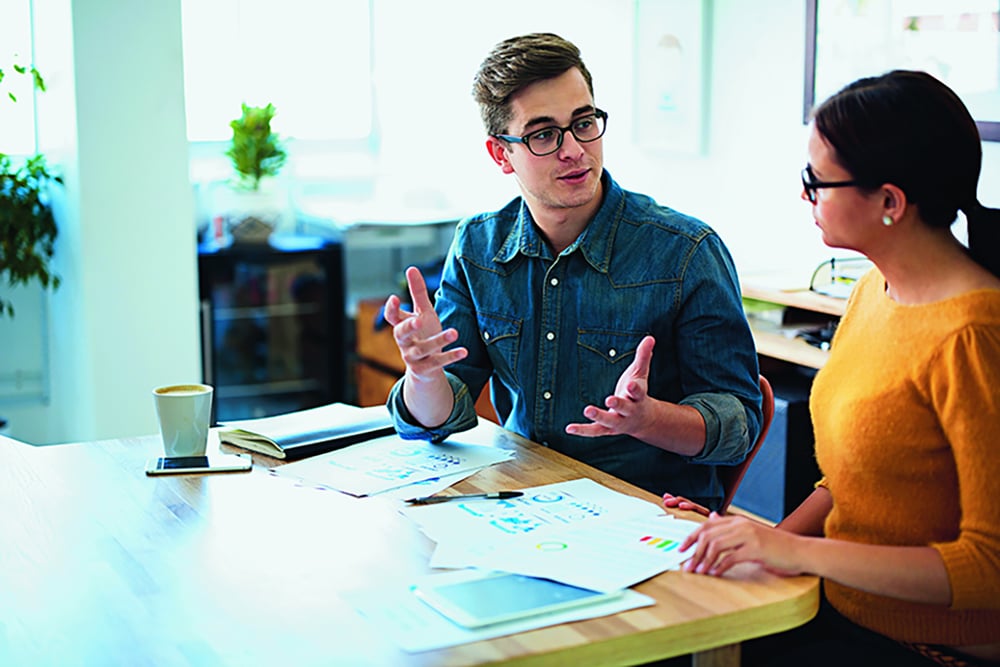 Man speaking to woman at an office desk