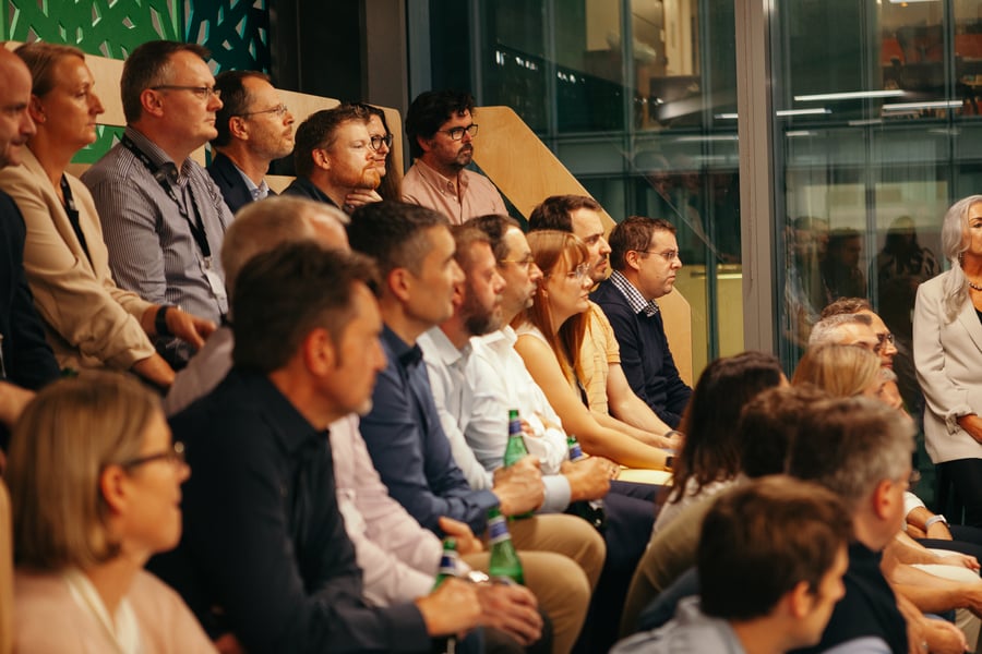 A close up image zoomed in on a number of people sitting in an audience in the Edenred office breakout space during a presentation. They are shown sitting and listening to the presentation.